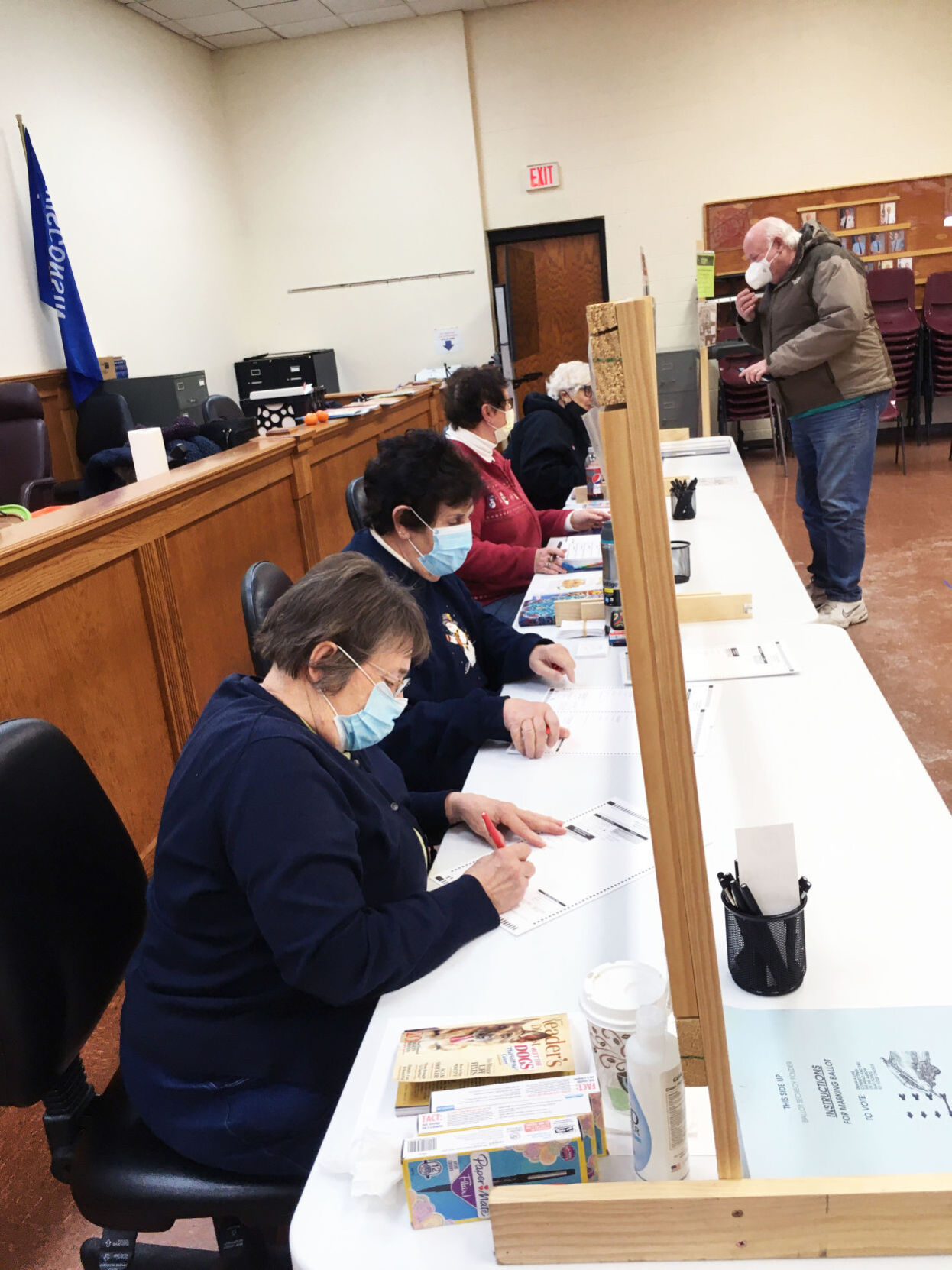 Poll workers and voters separated by makeshift window at Burlington Town Hall
